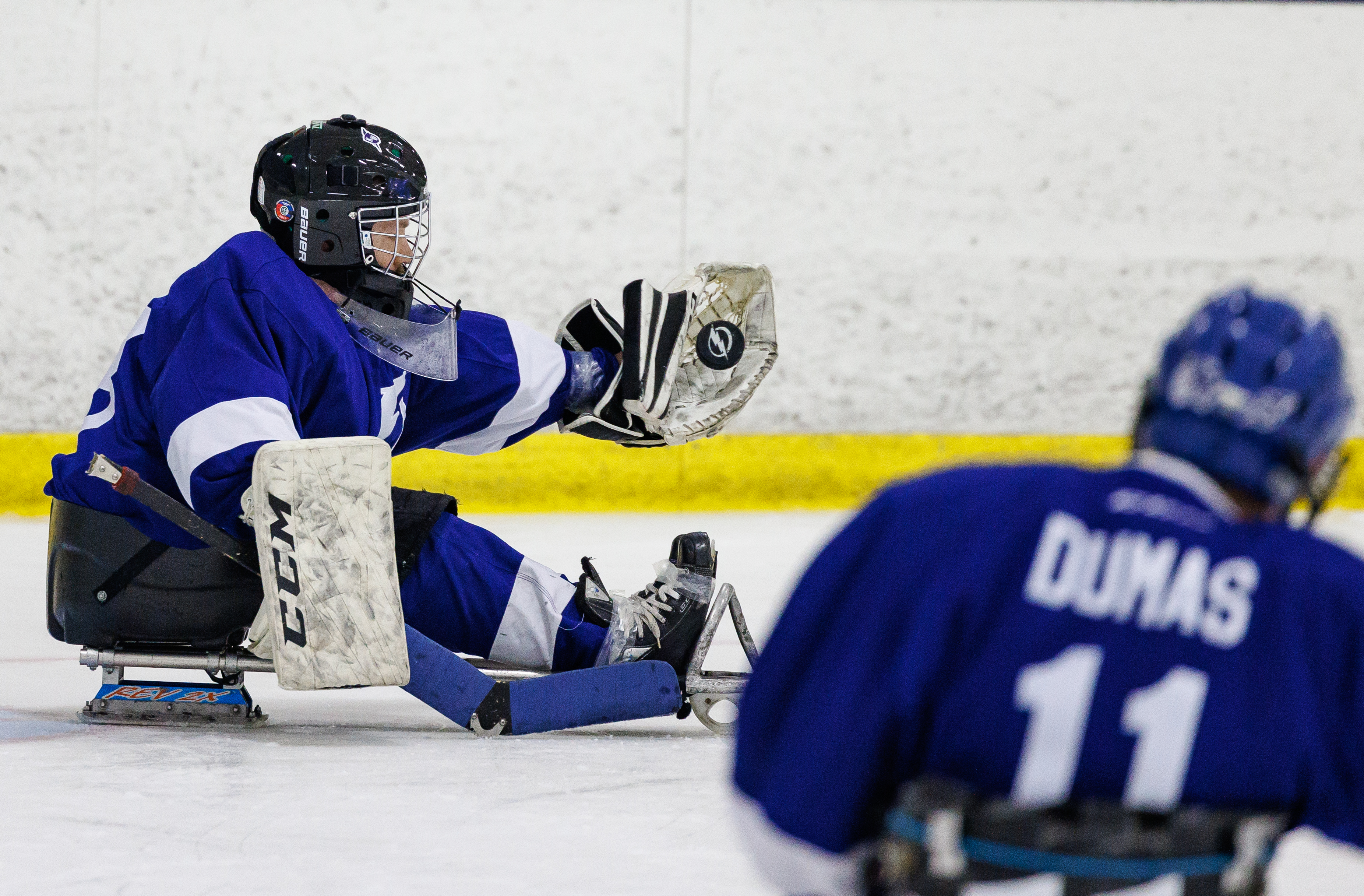 For Goalies:

Goalies have one stick with picks at the heel of the blade as well as a glove that also has picks sewn at the base to help them move from post to post. Players and goalies wear the same equipment as stand-up players, however many will wear shoes instead of skates, a different style of pant and must have a cage secured to their helmet.